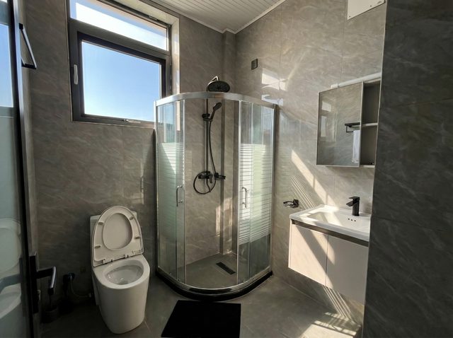 Bathroom with curved glass shower enclosure and daylight